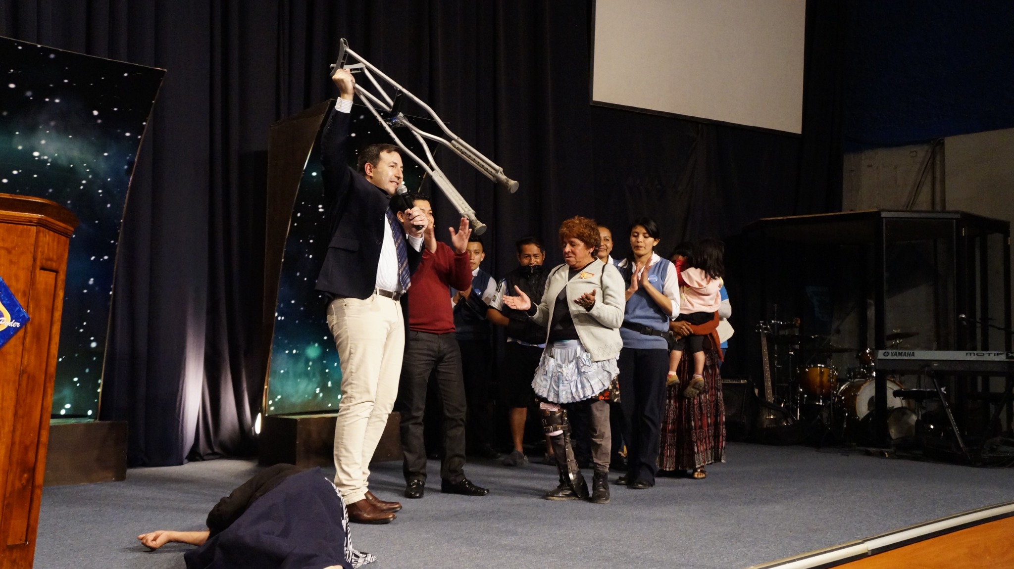 Momento de testimonio de fe durante una reunión cristiana en el escenario.